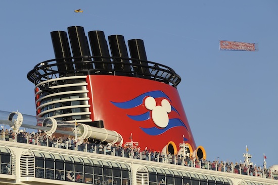 A Plane Tows a Banner Overhead Saluting the Ship’s Maiden Voyage A Plane Tows a Banner Overhead Saluting the Ship’s Maiden Voyage
