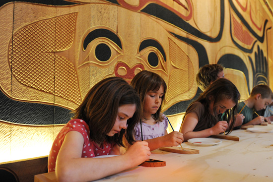 Children paint a wooden feather to add to a special Disney Cruise Line totem pole. Children paint a wooden feather to add to a special Disney Cruise Line totem pole.