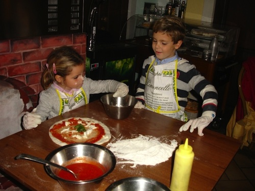 Kids enjoy authentic Italian cuisine by making their own pizza in Naples