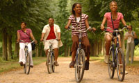 Family of four riding bikes on a forest trail during their family adventure